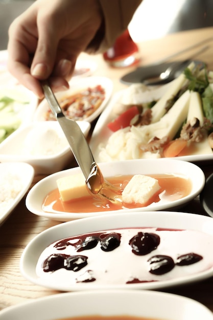 mâini pregătind sos